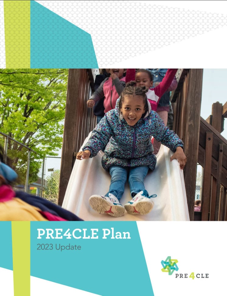A young girl in a patterned jacket slides down a playground slide, smiling, with other children waiting behind her. The image is part of the PRE4CLE Plan 2023 Update cover.