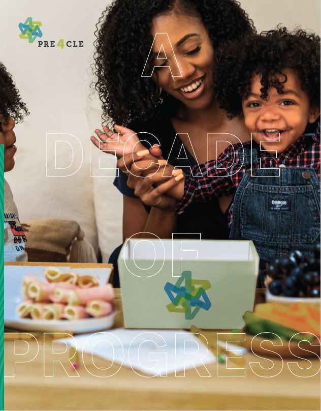 A smiling woman and young child sit at a table with snacks and a box, overlaid with the text "A Decade of Progress.